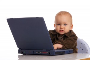 baby boy with laptop is looking mad